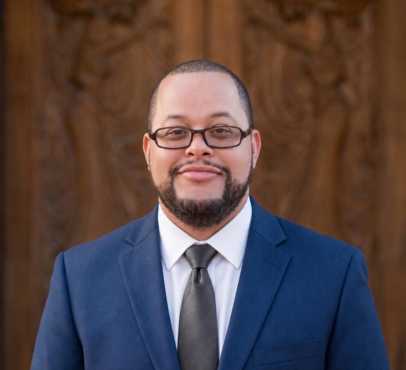 Ashley Reddick wearing a blue suit and glasses
